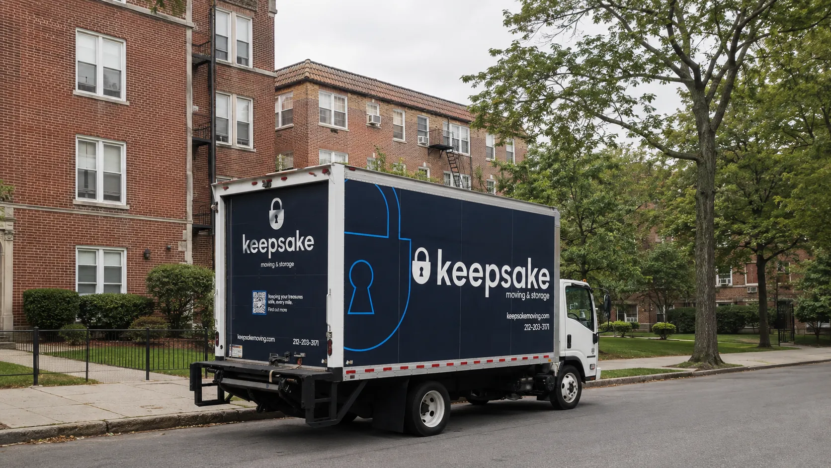 A Keepsake cab-over truck parked on a residential block with brick apartment buildings.